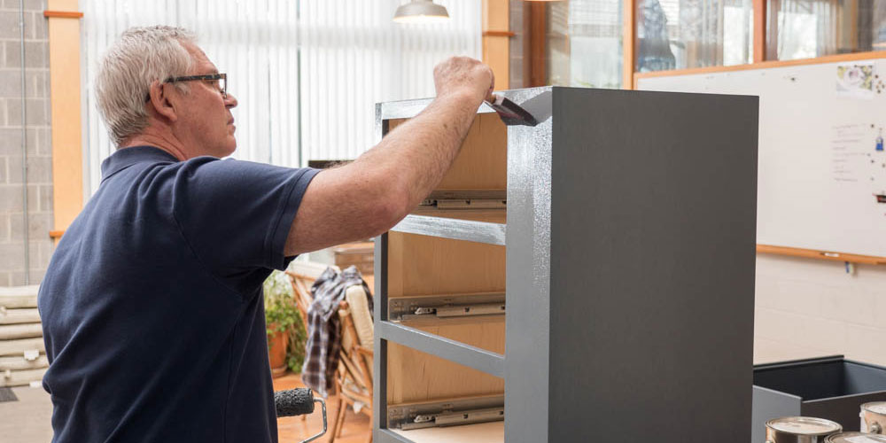 Fabricator painting an exhibit element in our shop