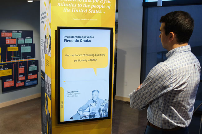 Graham Unruh interacting with the digital touchscreens on the exhibit columns.