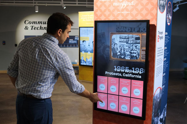 Graham Unruh interacting with the digital touchscreens on the exhibit columns.