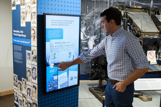 Graham Unruh interacting with the digital touchscreens on the exhibit columns.