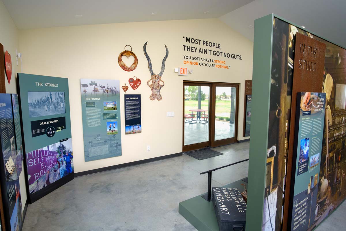 A corner A/V unit surrounded by interpretive panels and wall-mounted art