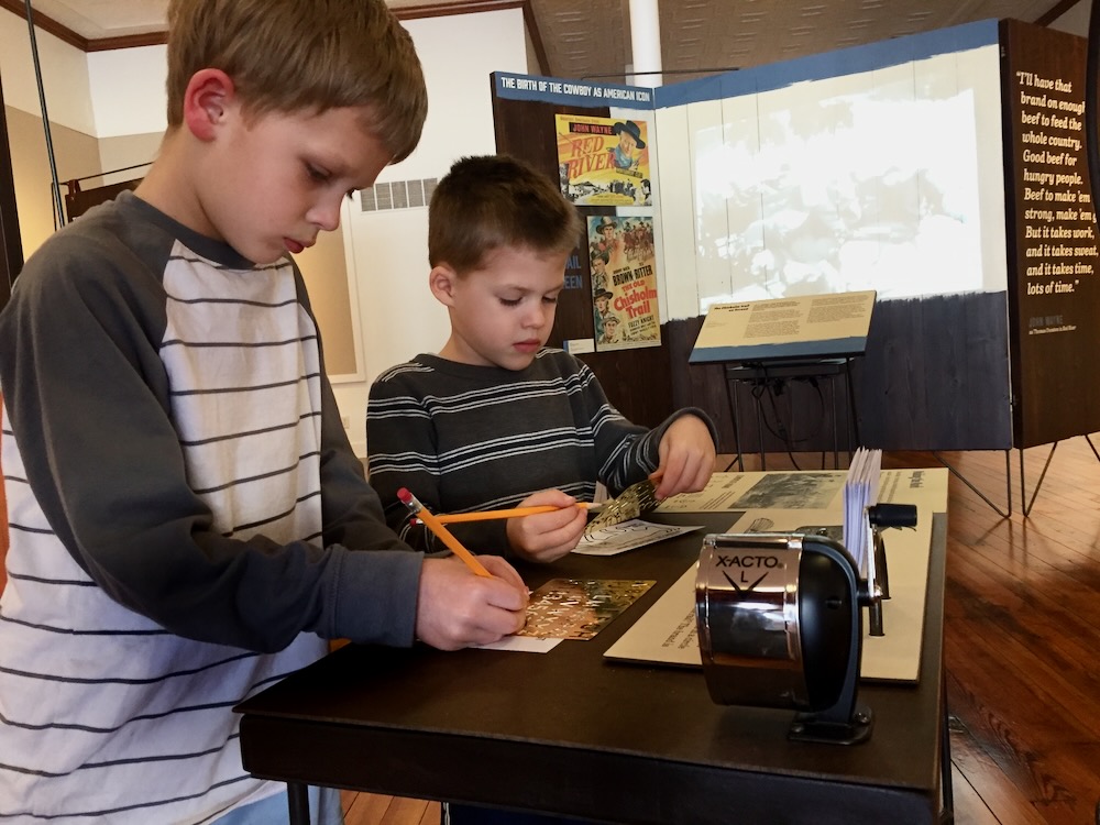 Brand Your Beeves interactive with video projection on wooden structure in background